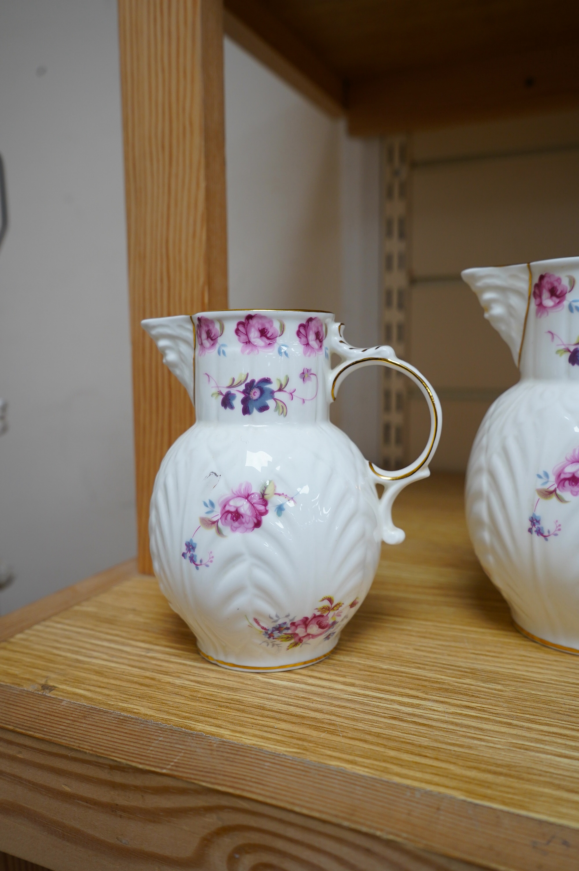 A set of six Coalport blue, gilt and white octagonal coffee cups and saucers, (three cups cracked), and two modern Coalport “Caughley Mask’’ jugs, (14), tallest 14.5cm. Condition - varies